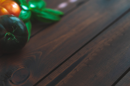 Assorted vegetables and herbs on a dark brown wooden table.の写真素材