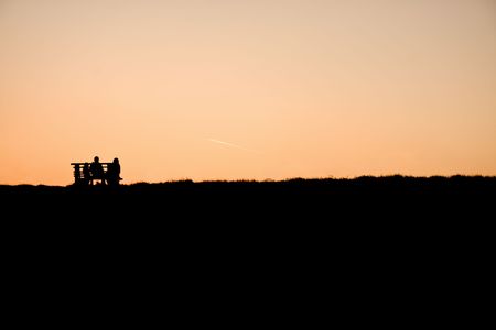 family on bench at eveningの写真素材