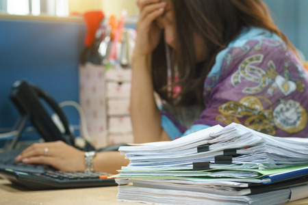 headache of business woman from a lot of paperworkの写真素材