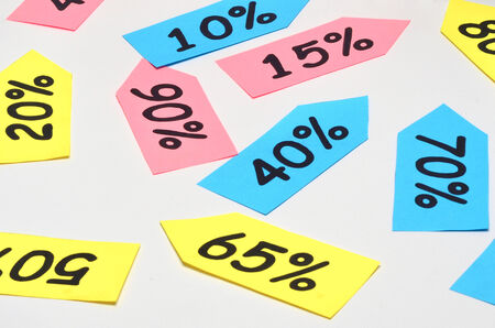 Background with colored tags of price discounts and percents over whiteの写真素材