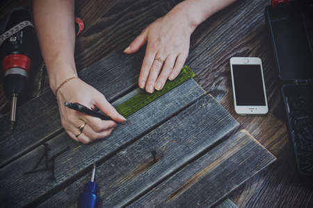 Girl works in home with the wooden planks.の写真素材