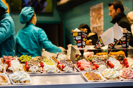 Baker in bakery with traditional  sweet Belgian waffles dessert in the shopの写真素材
