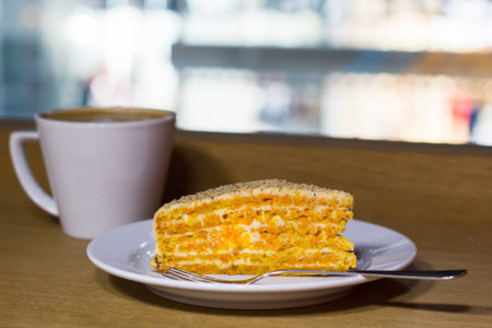 Carrot cake and white cup of coffee in cafeの写真素材