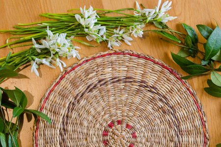 Wooden table with spring snowdrops and green plants background