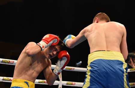 Kyiv, UKRAINE - March 20, 2015 : PRUDKYI Oleg (UA) and SHAN Jun (China)  in the ring during boxing fight Ukraine Otamans vs China Dragons in Palace of Sport in Kiev, Ukraineのeditorial素材
