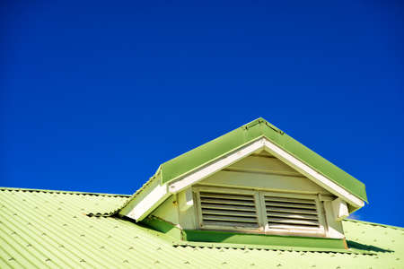 Light green building roof with ventilation on blue sky background, copy spaceの写真素材