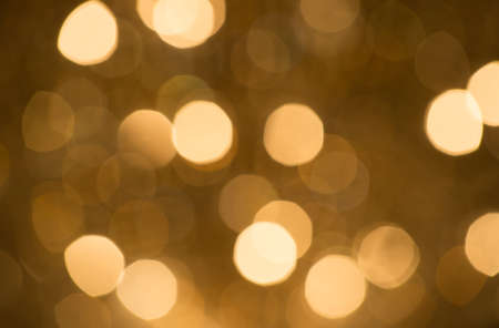 sparkling abstract bokeh background golden color with glitter circles with no peopleの写真素材