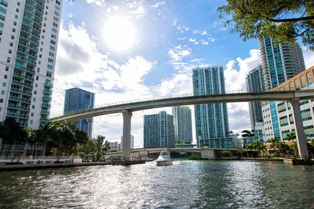 Downtown Miami along the Miami River inlet with Brickell Key in the background and yacht cruising...