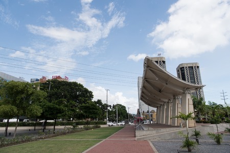 City or town street with green plants and modern architecture on summer day on blue skyのeditorial素材