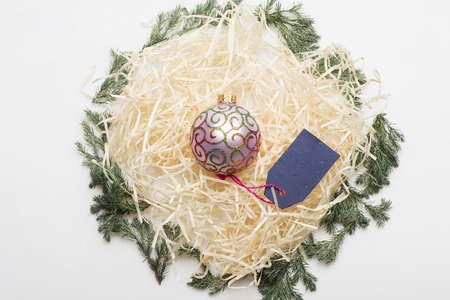 Colorful Christmas or New Year decoration with rose gold christmas ball, blue tag with rose thread and tree branch on white backgroundの写真素材