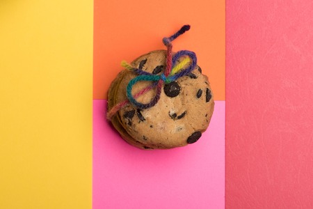 Chocolate chip cookies tied with rainbow string on colorful background, top viewの写真素材