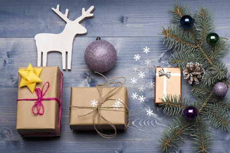 Christmas baubles and decorations including gift with rose thread, golden yellow bow, gift with silver bow, gift with thread, golden bow, christmas deer, snowflakes, violet silver christmas ball, christmas tree with brown pine cone and balls on vintage woの写真素材