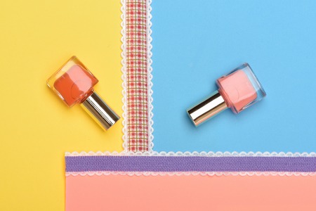 Bottles with nail polish on colorful background