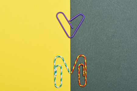 Colour decorative paper clips with heart sign on colorful background, office suppliesの写真素材