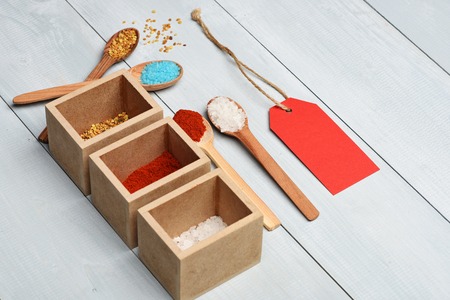 Set of ingredients for cooking of salt, paprika, spices, red tag with thread and wooden spoons on vintage wooden white backgroundの写真素材