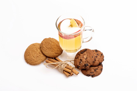 Glass of delicious glintwein or mulled hot wine, cinnamon and oatmeal cookies isolated on white backgroundの写真素材