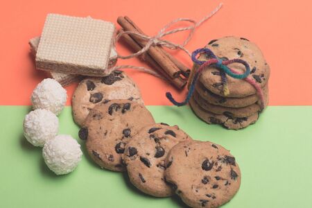 Chocolate chip cookies tied with rainbow string and placed around, cinnamon with thread, waffles and...