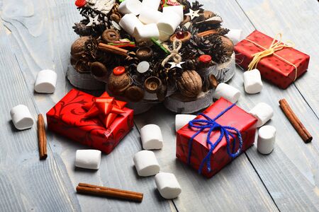 set of christmas or new year decoration with colorful presents or gifts with marshmallow, xmas wreath and cinnamon on white vintage wooden backgroundの写真素材