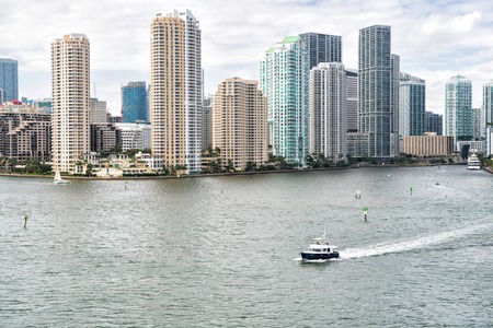 Aerial view of Miami skyscrapers with blue cloudy sky,white boat sailing next to Miami downtownの写真素材