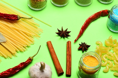 set of colorful spices with garlic, salt, cinnamon, pasta, jars, curry, paprika, turmeric, chili...
