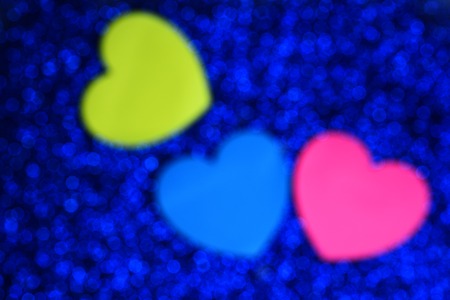 defocused background made by bokeh blue light with colorful valentine hearts or cards, copy spaceの写真素材