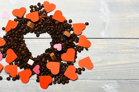 set of paper red valentines with aroma coffee beans in circle forming heart shape sign on grey vintage wooden background, copy spaceの写真素材