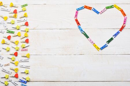 colorful valentine heart made from clothespins on white vintage wooden background, copy spaceの写真素材