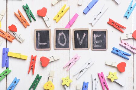 set of colorful clothespins with yellow hearts and smiling stars around black boards with word Love...
