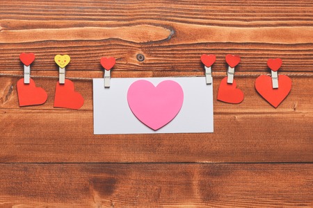 set of valentine card or hearts hanging on clothesline with emoji pegs on brown vintage wooden background, copy spaceの写真素材