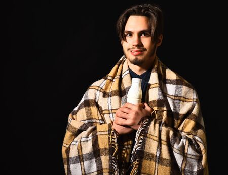 handsome bearded smiling man in checkered plaid holding kefir or yogurt on black studio background, copy spaceの写真素材