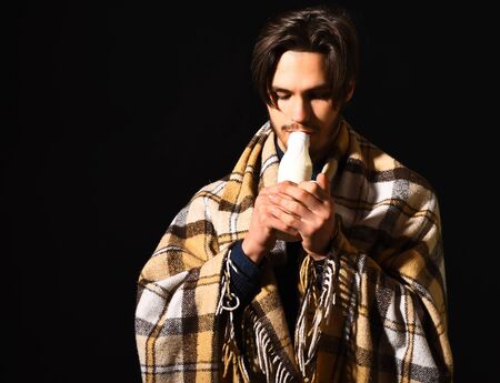 handsome bearded man in checkered plaid drink kefir or yogurt on black studio backgroundの写真素材