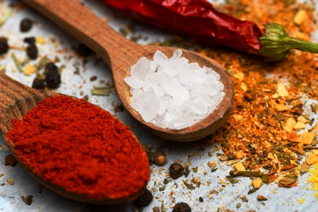 set of various aromatic spices of paprika, salt, chili pepper with spoons on vintage wooden blue background, side viewの写真素材