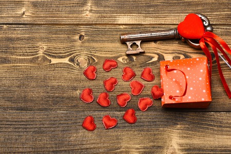 small cute decoration heart of red and silver straw, metallic key and present package on wooden background with nobody as love symbol of valentines day holiday celebration, copy spaceの写真素材
