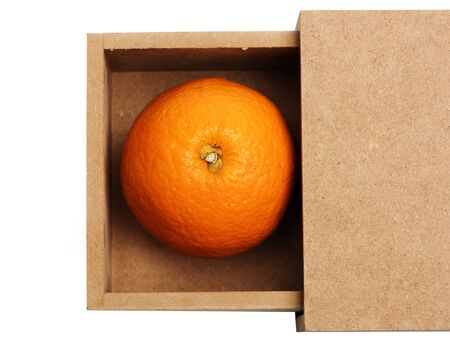 single orange citrus fruit with vitamin for healthy diet in wood or paper box isolated on white background, copy spaceの写真素材