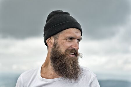 Handsome man hipster or guy with beard and moustache on smiling happy face in hat outdoor with...