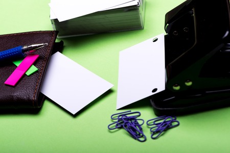 set of stationery for office: hole puncher, paper clips, box with blanks, wallet, pen, stickers on...