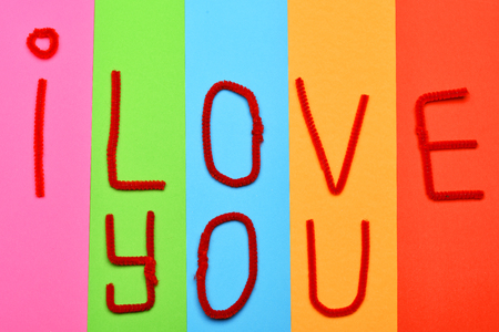 colorful background with pink, green, blue, orange, red papers with phrase i love you for valentines day, top viewの写真素材