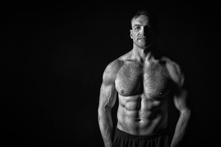 sexy muscular male torso and body with hairy chest of handsome macho man or athlete guy workout or training, black and whiteの写真素材