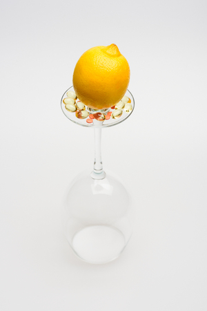 set of lemon on wineglass with pills and capsule isolated on white background, side viewの写真素材