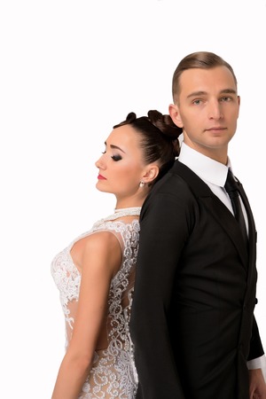 young couple of handsome businessman or gentleman guy in black formal suit of jacket and tie with pretty brunette woman or sexy girl with red lips on cute face in wedding dress isolated on whiteの写真素材