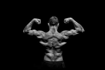 handsome bodybuilder man or sexy muscular guy with athlete body and back training and posing, black and whiteの写真素材