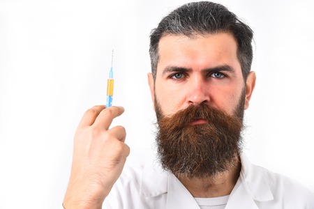 caucasian doctor or unshaven hipster, postgraduate student holding syringe in medical gown isolated on white studio background.の写真素材