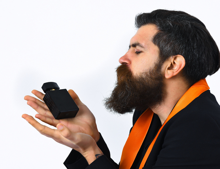 caucasian satisfied hipster with moustache have acid orange tie on suit and holding perfume isolated on white studio backgroundの写真素材