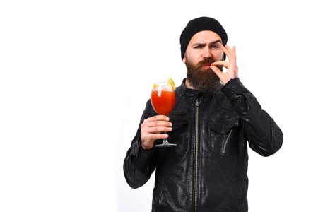 caucasian satisfied hipster with moustache holding glass of alcoholic beverage or fresh cocktail in rock black style isolated on white studio backgroundの写真素材
