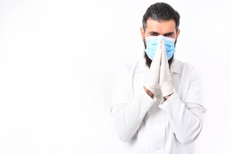 caucasian doctor or unshaven hipster, postgraduate student in mask, medical gown and gloves isolated on white studio background.の写真素材
