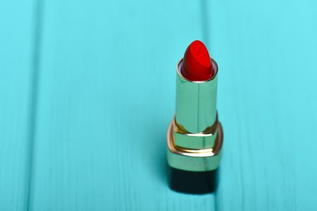red lipstick on turquoise blue wooden background, copy space, selective focusの写真素材