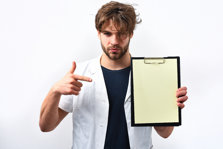 Bearded man, long beard. Brutal caucasian serious doctor or unshaven hipster, postgraduate student holding clipboard in medical gown isolated on white background. Medicine conceptの写真素材
