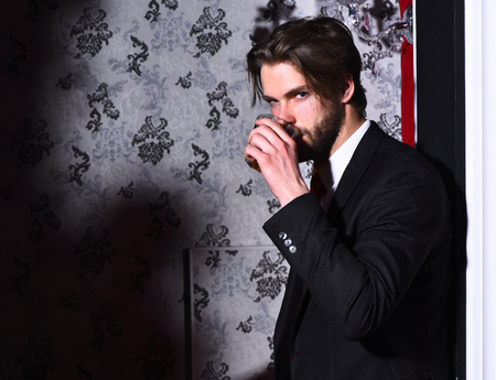 bearded man, businessman, long beard, brutal caucasian hipster with moustache holds glass of whiskey has serious face, unshaven guy with stylish hair in suit and red tie wallpaper backgroundの写真素材