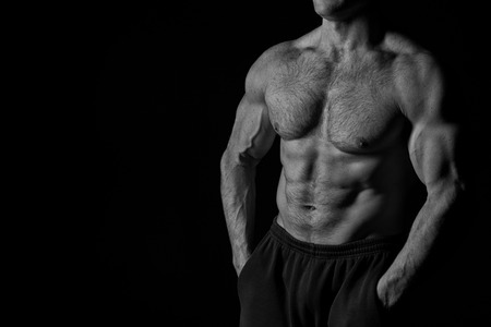 handsome bodybuilder man or sexy muscular guy with athlete body, torso and chest training sport and posing in gym, black and white, copy spaceの写真素材
