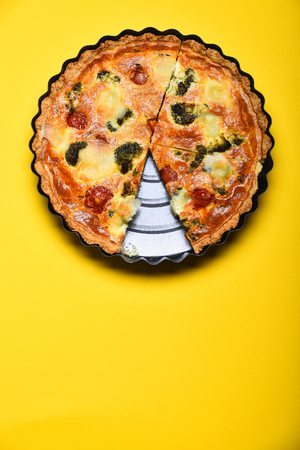 pizza or vegetable pie on tray near on yellow background, copy spaceの写真素材